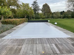 Epervier winterafdekking op een zwembad, gebruikt om het zwembad te beschermen tegen vuil en weersinvloeden in de winterperiode.